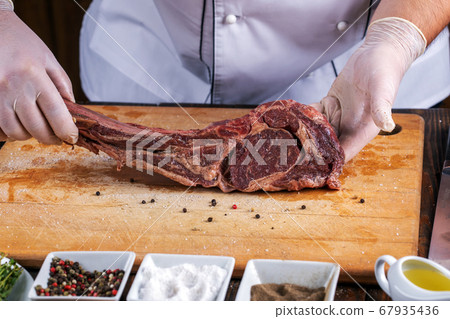 The chef prepares meat steak in his hands The chef prepares meat steak in his hands 67935436