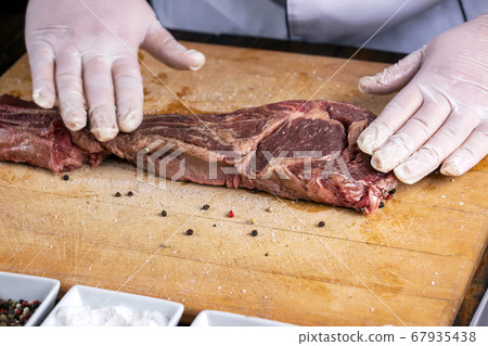 The chef prepares meat steak in his hands The chef prepares meat steak in his hands 67935438
