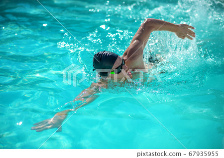 Man swimming on his side in the pool Man swimming on his side in the pool 67935955