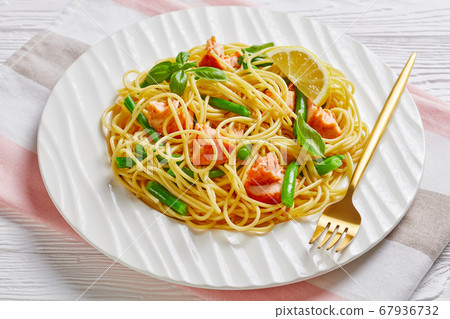 Salmon pasta with green beans on a white plate 67936732
