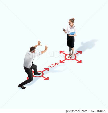 Studio shot of people demonstrating social distancing with arrows indicating the separation. 67936864