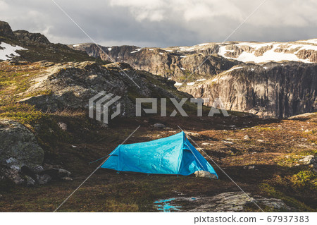 Tourist's tent stands in the mountains. Summer sunrise above beautiful rocks in Norway. Tourist's tent stands in the mountains. Summer sunrise above beautiful rocks in Norway. 67937383