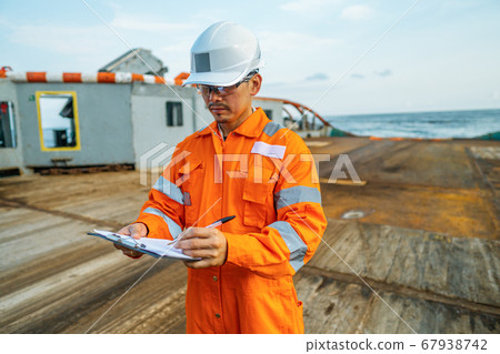 Filipino deck Officer on deck of offshore vessel or ship fills checklist. Paperwork at sea 67938742
