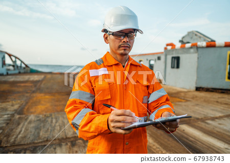Filipino deck Officer on deck of offshore vessel or ship fills checklist. Paperwork at sea 67938743