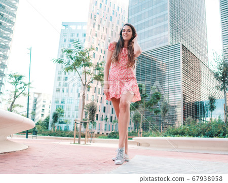 woman in sexy stylish dress posing in the modern city with skyscrapers on background woman in sexy stylish dress posing in the modern city with skyscrapers on background 67938958