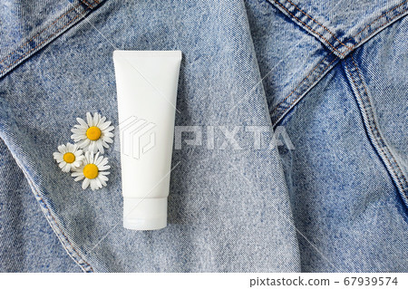 Cosmetics spa branding mock-up with camomile flowers on a denim background. Natural organic cosmetic packaging mock up. Top view, flower flatlay. Cosmetics spa branding mock-up with camomile flowers on a denim background. Natural organic cosmetic packaging mock up. Top view, flower flatlay. 67939574