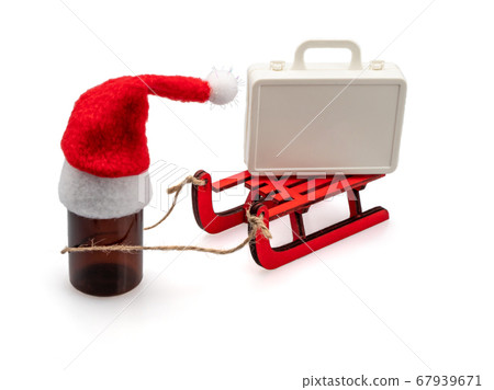 A bottle in a Santa hat carries a suitcase on a 67939671