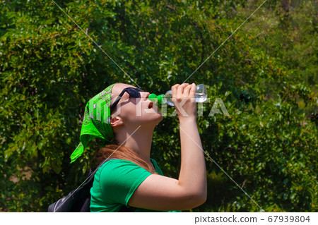Young girl holds a bottle of water in hand and Young girl holds a bottle of water in hand and 67939804