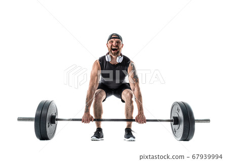 Aggressive bearded strong muscular Man in sportswear and headphones Doing A Deadlift Exercise. Aggressive bearded strong muscular Man in sportswear and headphones Doing A Deadlift Exercise. 67939994