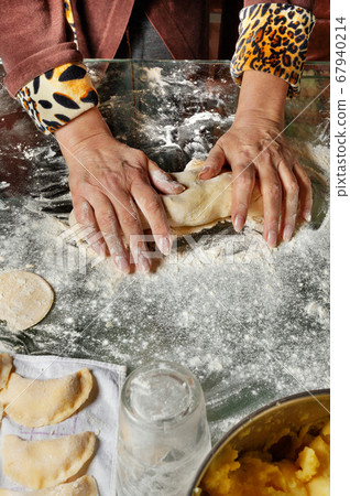 A housewife kneads dough with her hands for making A housewife kneads dough with her hands for making 67940214