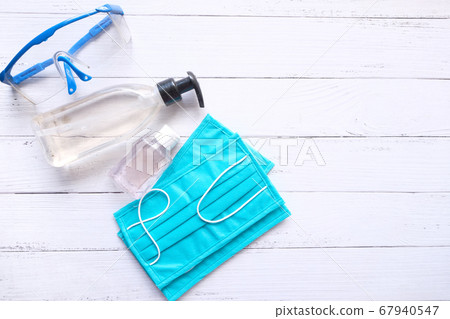 Surgical masks and hand sanitizer on wooden background Surgical masks and hand sanitizer on wooden background 67940547