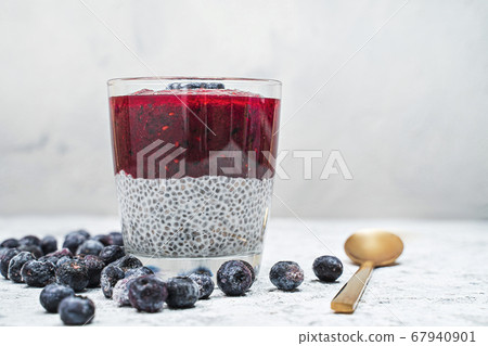 Healthy breakfast or morning snack with chia seeds and blueberries on white stone background, vegetarian food, diet and health concept 67940901