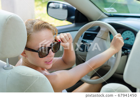 Woman driving a car 67941450