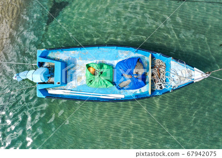 Small Fishing Boat anchored in a shallow lagoon. Small Fishing Boat anchored in a shallow lagoon. 67942075
