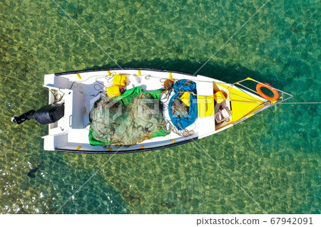 Small Fishing Boat anchored in a shallow lagoon. 67942091