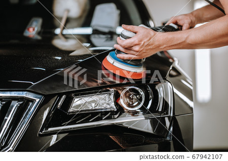 Professional detailing a car in car studio, hands with orbital polisher, scratching remover, vehicle care concept 67942107
