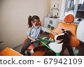 Little dentist treating toy patient 67942109