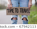 Girl holds cardboard plate with inscription words Time to travel 67942113