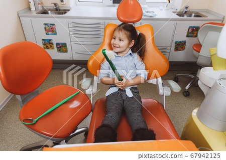 Cheerful little patient with huge toothbrush 67942125