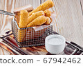fried cheese sticks with sour cream sauce on a wooden table 67942462