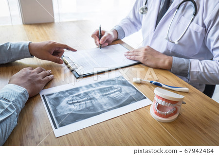 Professional Dentist and patient discussing jaw Professional Dentist and patient discussing jaw 67942484