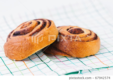 A cinnamon bun on a napkin on white 67942574