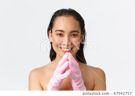 Personal care, women beauty, bath and shower concept. Close-up of pretty asian female standing naked in bathing gloves, steeple fingers thoughtful, making pleased face, smiling cunning Personal care, women beauty, bath and shower concept. Close-up of pretty asian female standing naked in bathing gloves, steeple fingers thoughtful, making pleased face, smiling cunning 67942757