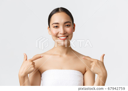 Beauty, cosmetology and spa salon concept. Close-up of satisfied beautiful asian female client in white towel smiling and pointing at herself, recommend beauty clinic and skincare procedures Beauty, cosmetology and spa salon concept. Close-up of satisfied beautiful asian female client in white towel smiling and pointing at herself, recommend beauty clinic and skincare procedures 67942759