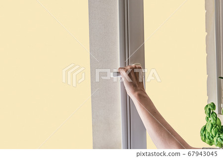 A woman's hand opens a window for airing room. 67943045