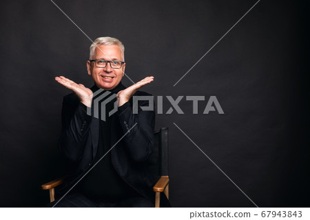 Emotional middle-aged man shrug. a middle aged man with white hair spreads his hands around his face in an emotional gesture Emotional middle-aged man shrug. a middle aged man with white hair spreads his hands around his face in an emotional gesture 67943843