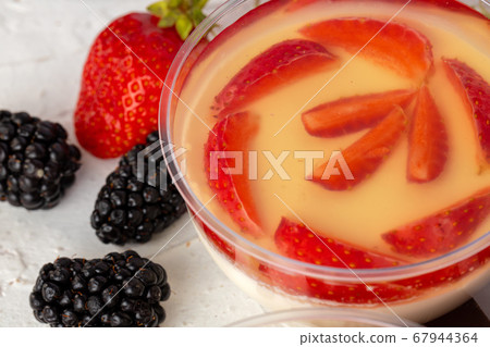 Mousse dessert with berry topping on grey surface Mousse dessert with berry topping on grey surface 67944364