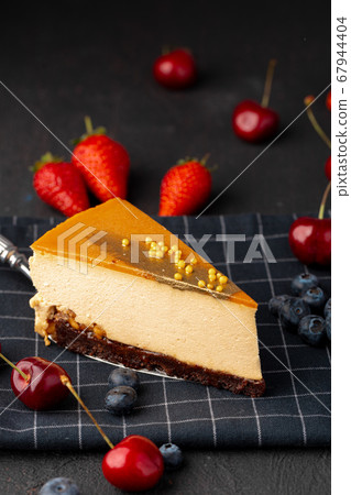 Piece of souffle cake with caramel top served with berries 67944404