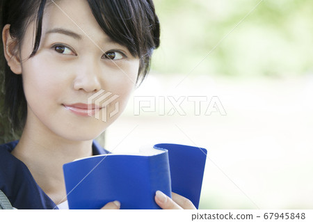 Junior high school girl reading a book Junior high school girl reading a book 67945848