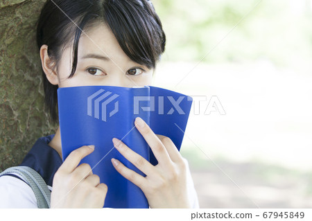 Junior high school girl reading a book Junior high school girl reading a book 67945849