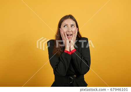 Joyful Female Holds Hands To Face In Surprise And Reacts To Surprise. Shocked 67946101
