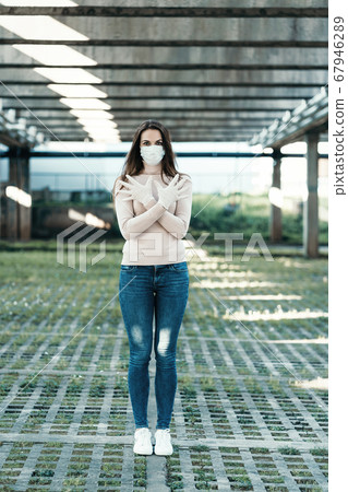 Young girl in medical mask and gloves shows stop sign 67946289