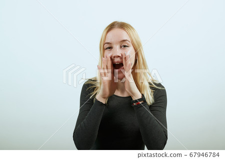Noisy Girl Holds Her Hands To Mouth And Screams Loudly. The Concept Of Noise 67946784