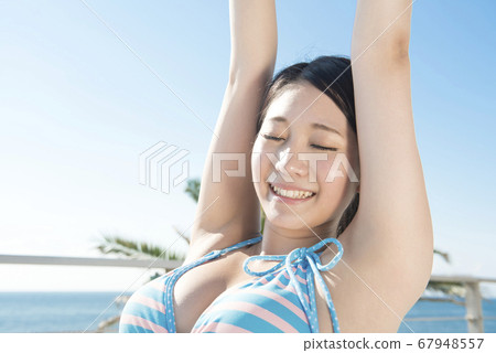 Swimsuit woman sitting on a beach chair Swimsuit woman sitting on a beach chair 67948557