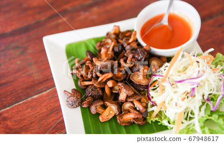 Delicious fried mushrooms in plate on wooden Delicious fried mushrooms in plate on wooden 67948617