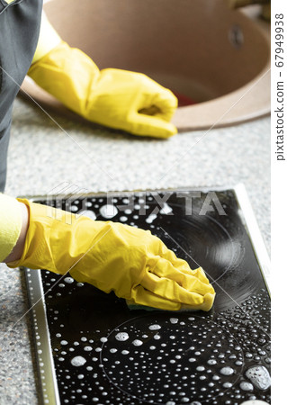 Person wipes kitchen worktop using degreaser spray detergent stove cleaner Person wipes kitchen worktop using degreaser spray detergent stove cleaner 67949938