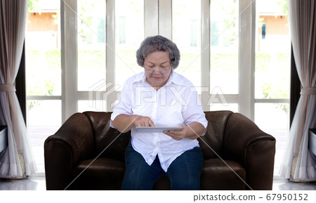 asian grandmother chating online with tablet asian grandmother chating online with tablet 67950152
