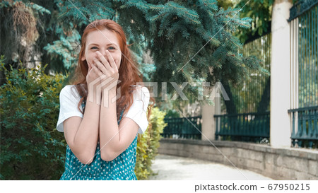 Smiling beautiful redhead girl laughs at joke. 67950215