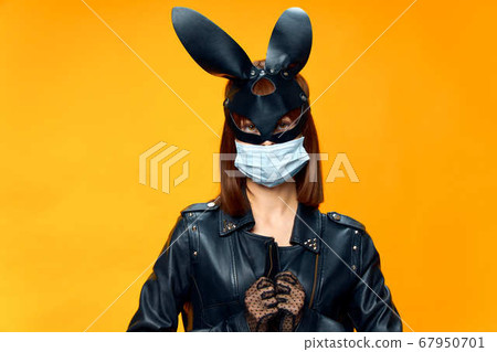 Female rabbit mask posing sexually in a medical mask from coronavirus 67950701
