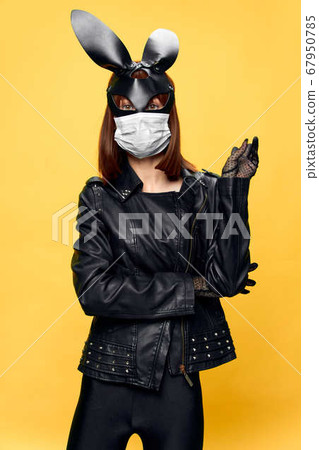 Female rabbit mask posing sexually in a medical mask from coronavirus Female rabbit mask posing sexually in a medical mask from coronavirus 67950785
