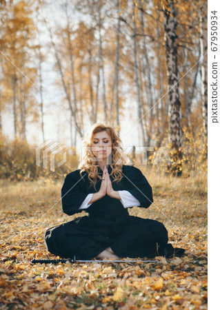 European woman with a katana in a kimono. the girl trains martial arts. a woman in the autumn forest. a warrior with a cold weapon in his hands 67950934