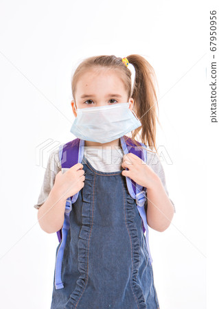 1 September. first-grader in medical school is going to school. little girl on home distance learning. child with school backpack works. the student is doing homework. isolated on a white background 67950956