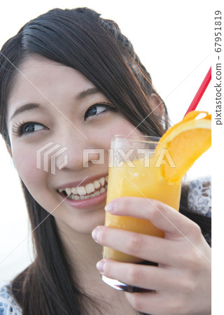 女人在海邊喝一杯雞尾酒 女人在海邊喝一杯雞尾酒 67951819