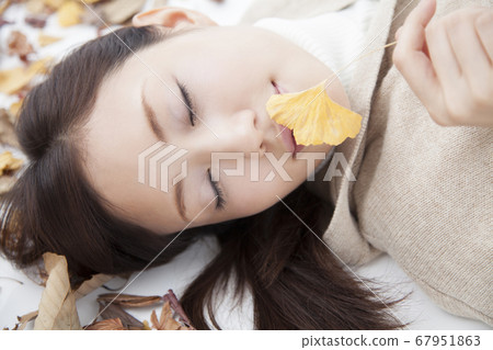 A woman lying on the fallen leaves A woman lying on the fallen leaves 67951863