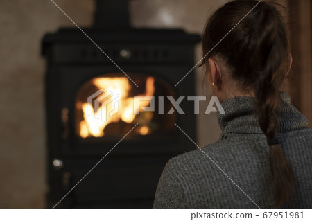 Portrait of pretty caucasian girl spending time in evening at home by fireplace Portrait of pretty caucasian girl spending time in evening at home by fireplace 67951981