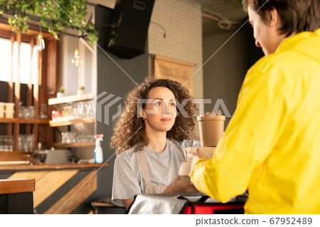 Waitress giving packaged boxes to deliver boy Waitress giving packaged boxes to deliver boy 67952489